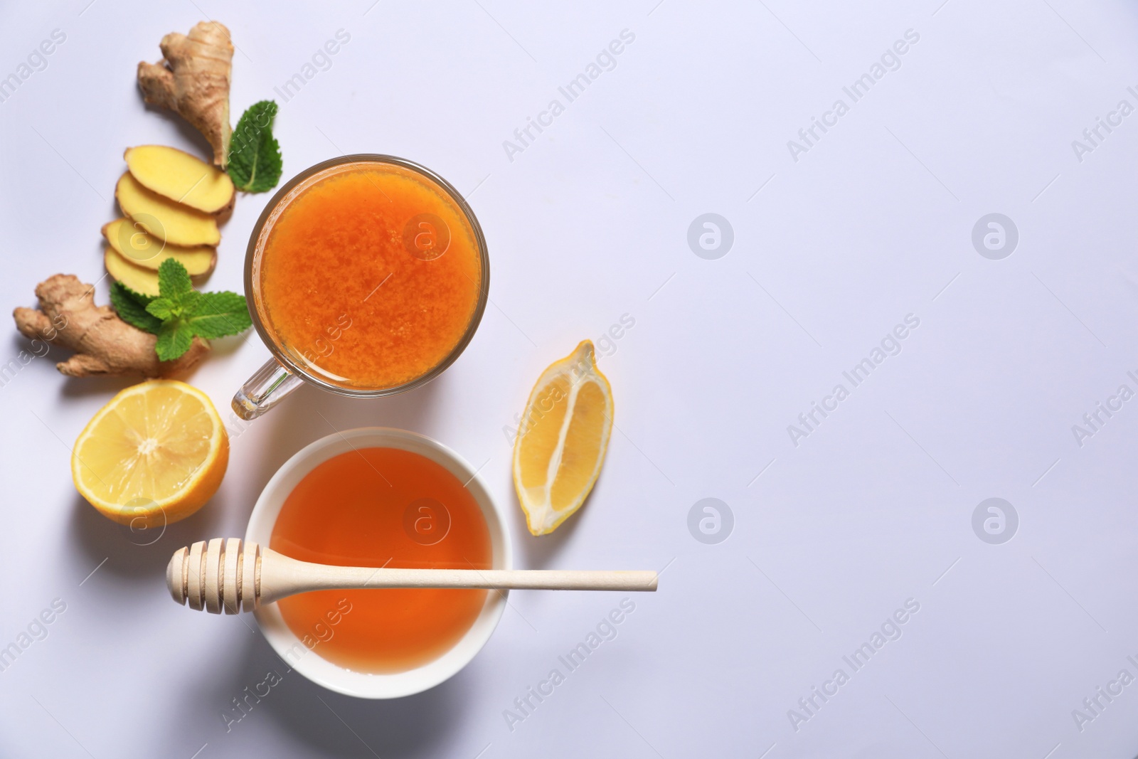 Photo of Delicious ginger tea and ingredients on white background, flat lay. Space for text