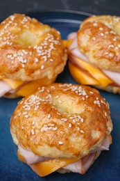 Photo of Delicious bagels with ham and cheese on plate, closeup