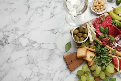 Photo of Set of different delicious appetizers served on white marble table, flat lay. Space for text