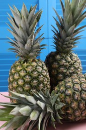 Photo of Delicious ripe pineapples on pink table, closeup