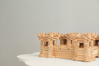 Photo of Wooden fortress on white table, space for text. Children's toy