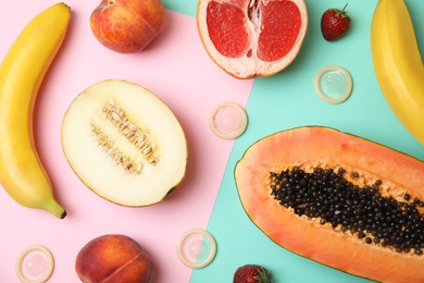 Photo of Flat lay composition with condoms and exotic fruits on color background. Erotic concept