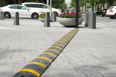 Photo of City street with striped plastic speed bump