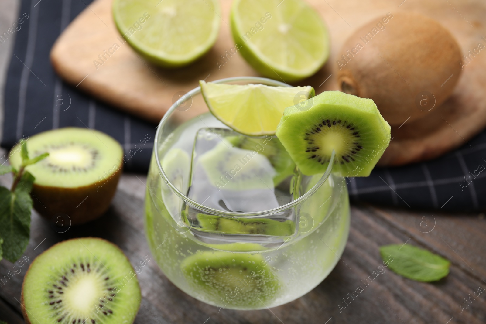 Photo of Glass of refreshing drink with cut kiwi on table, closeup