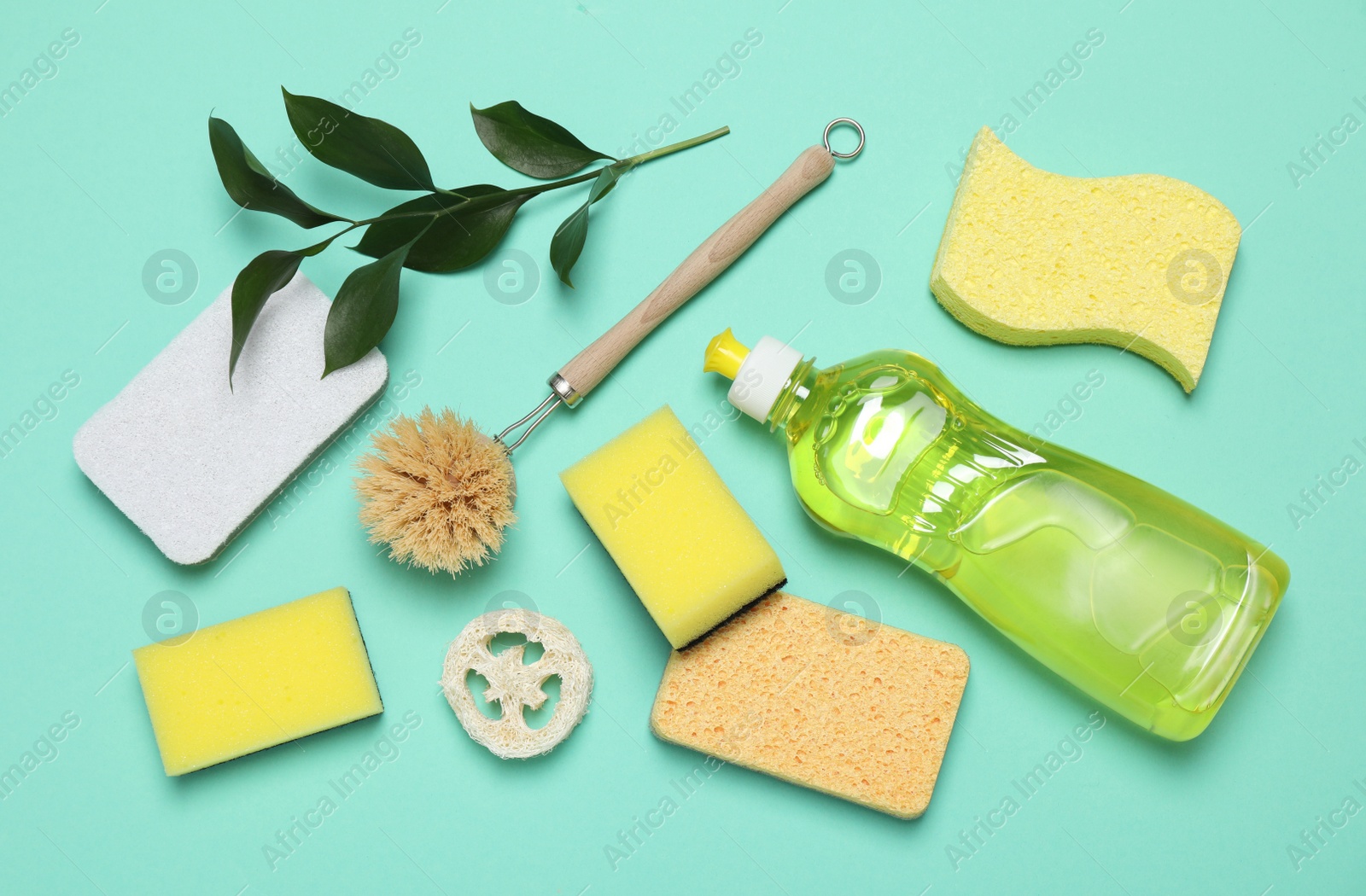 Photo of Sponges and other cleaning products on turquoise background, flat lay