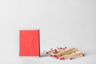 Photo of Cardboard box and matches on light background. Space for design