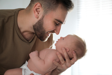 Photo of Father with his newborn son at home