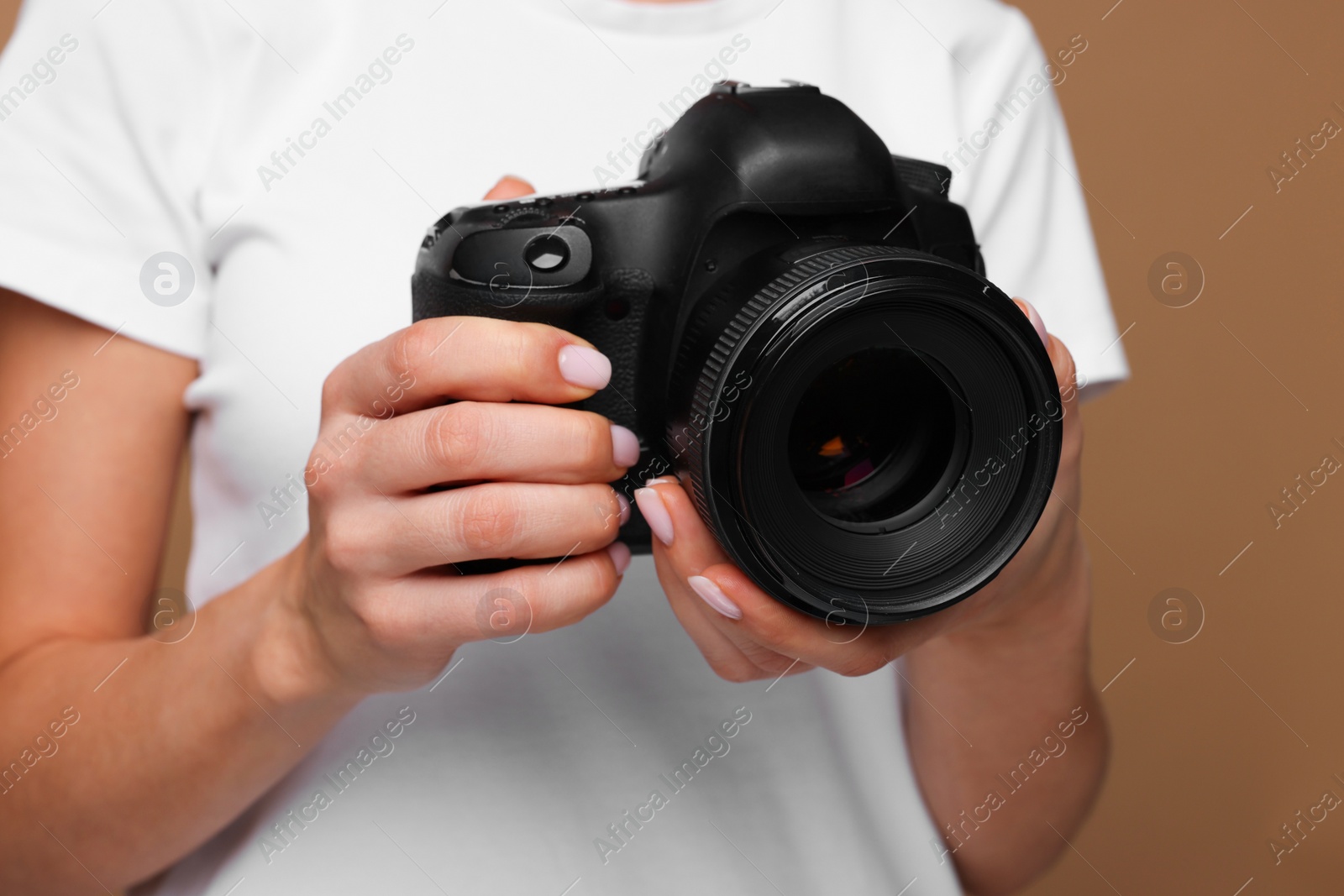 Photo of Photographer with camera on brown background, closeup