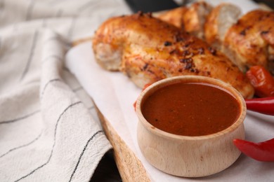 Photo of Baked chicken fillets and marinade on table, closeup. Space for text