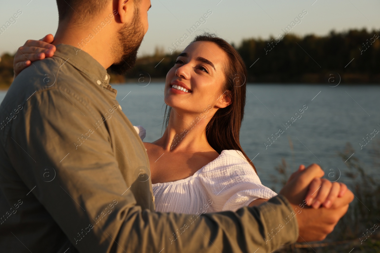 Photo of Beautiful couple dancing near river at sunset