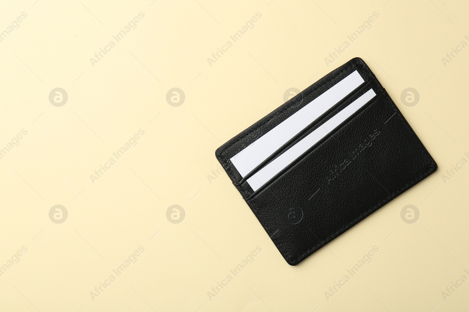 Photo of Leather business card holder with blank cards on beige background, top view. Space for text