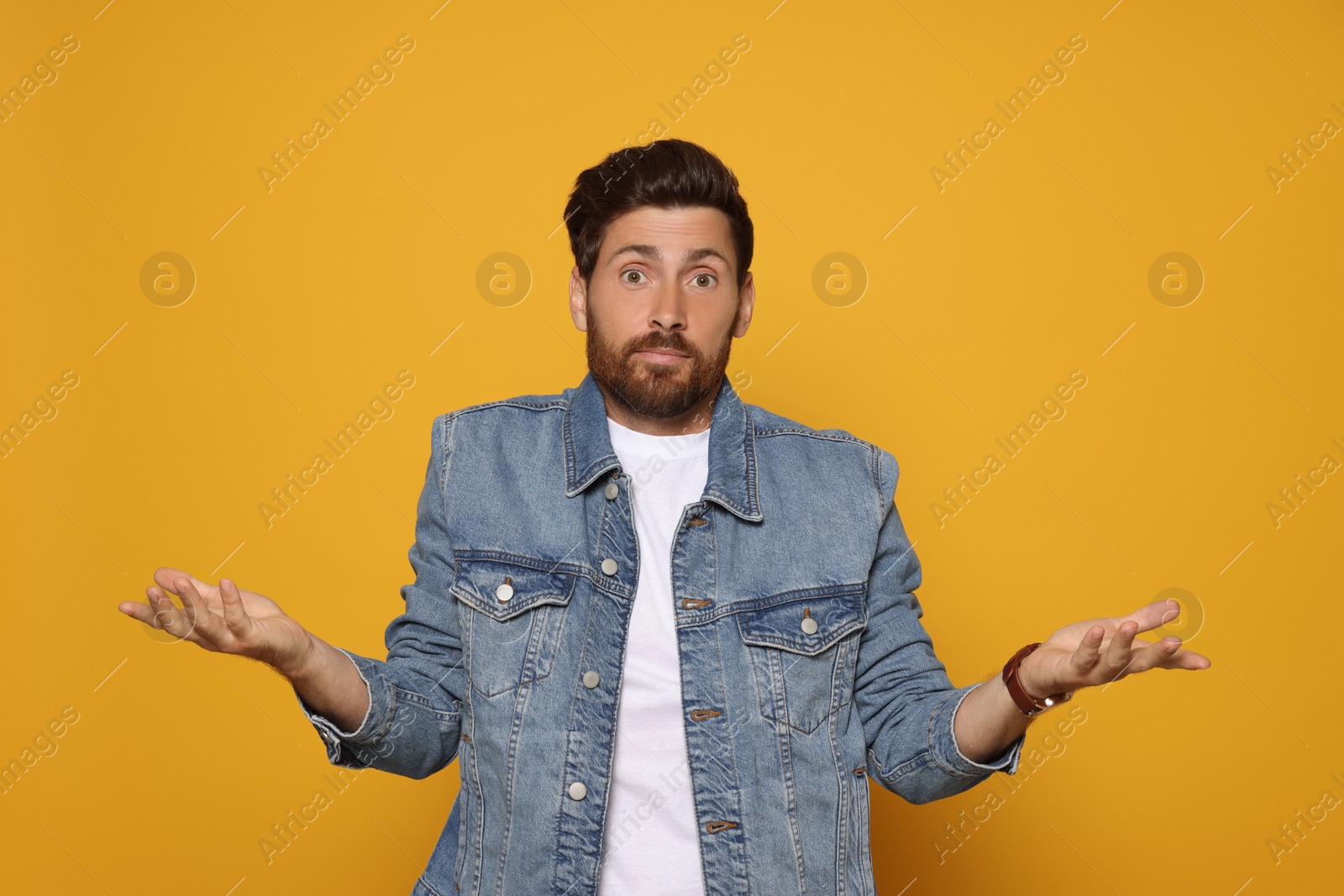 Photo of Portrait of surprised bearded man on orange background