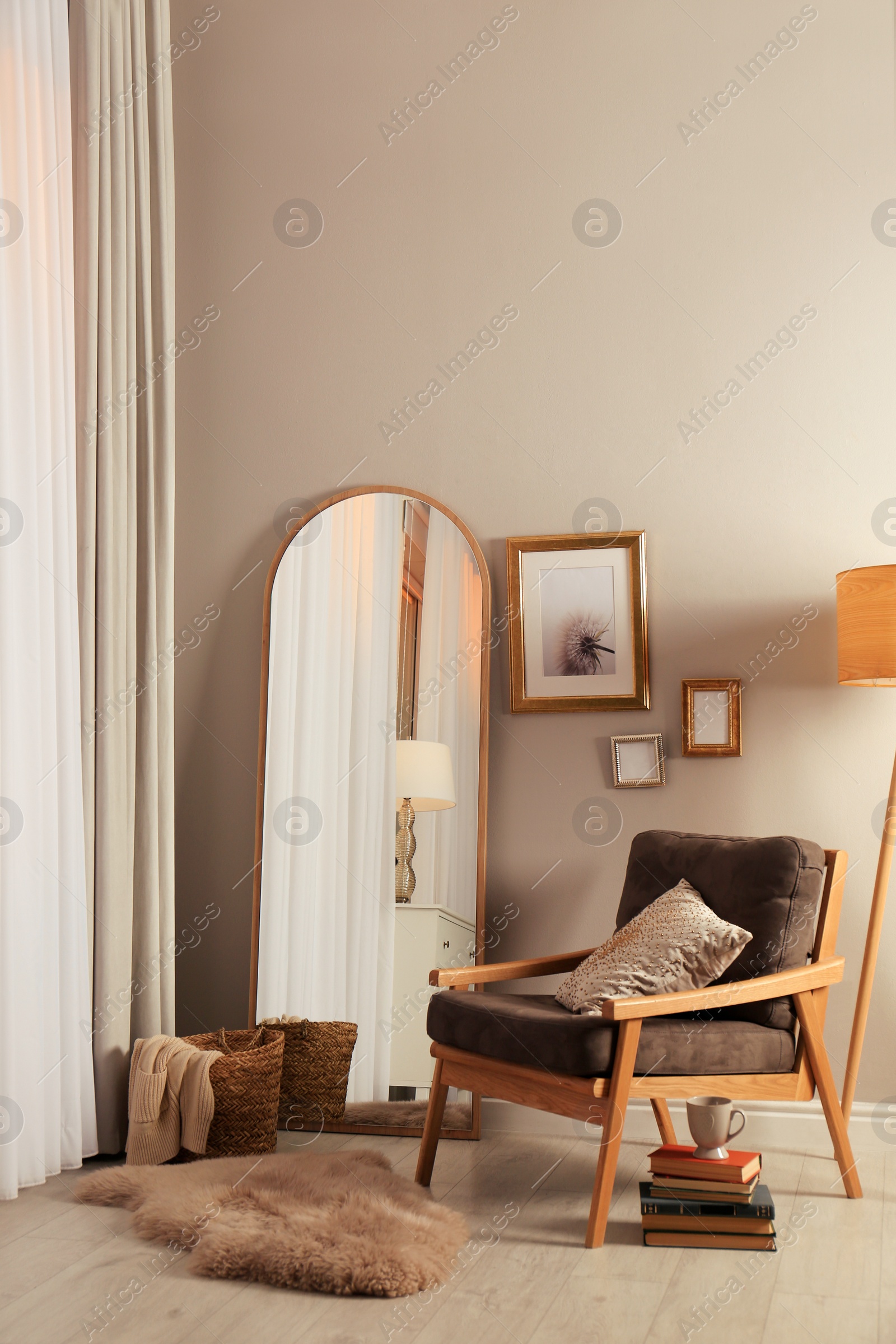 Photo of Stylish room interior with large mirror and comfortable armchair