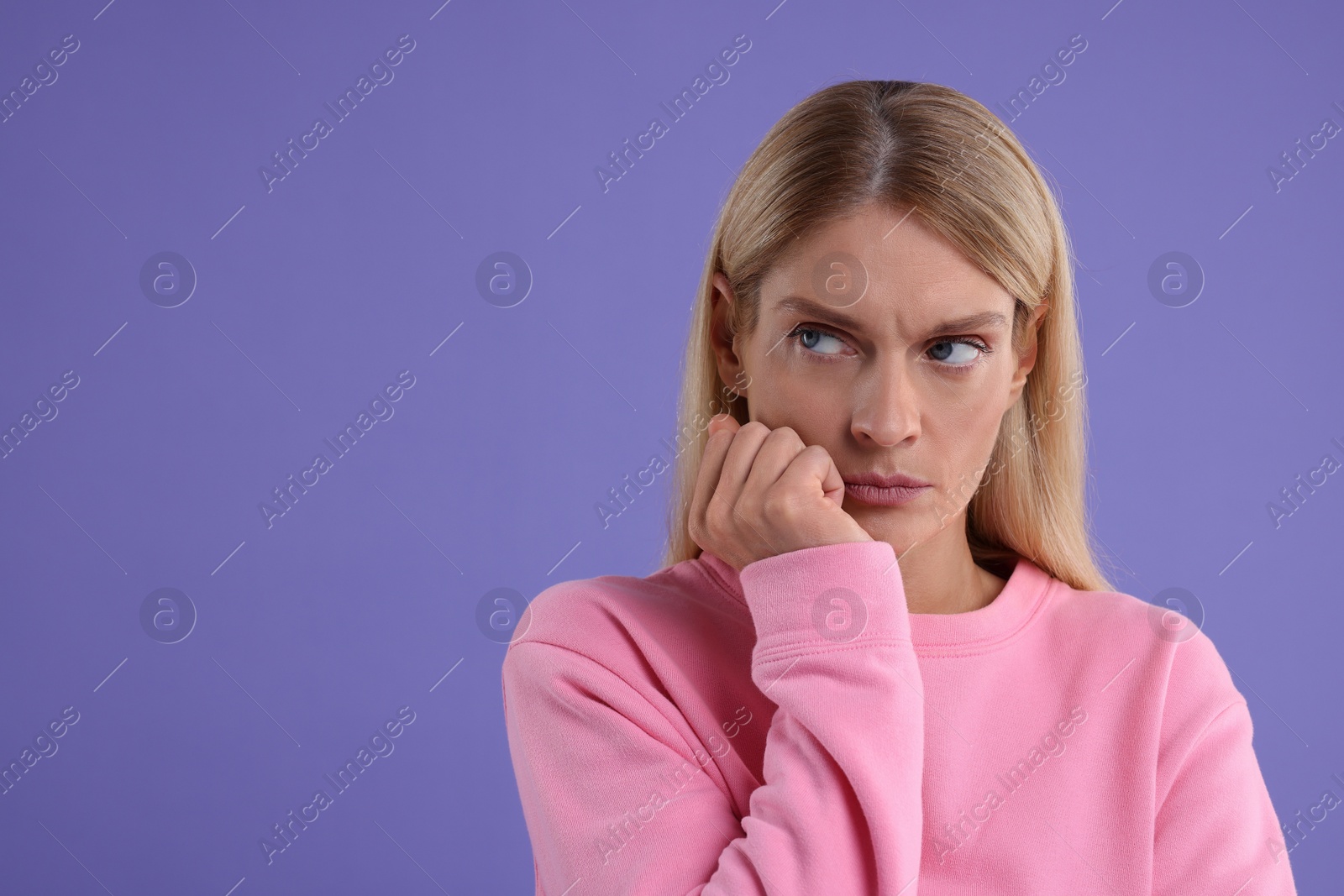 Photo of Resentful woman on purple background. Space for text