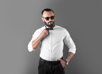 Portrait of handsome tattooed man on grey background