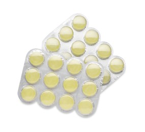 Photo of Blisters with yellow cough drops isolated on white, top view. Cold remedies