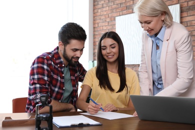 Female notary working with young couple in office