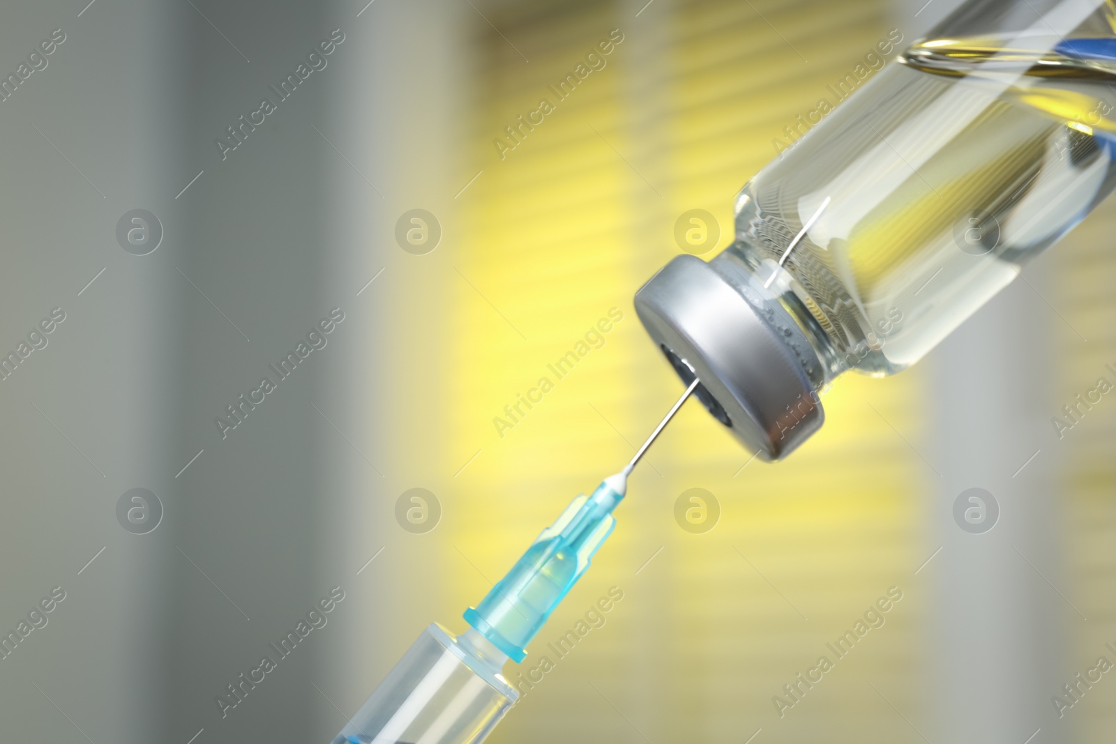 Photo of Filling syringe with medication from vial against blurred background, closeup. Vaccination and immunization