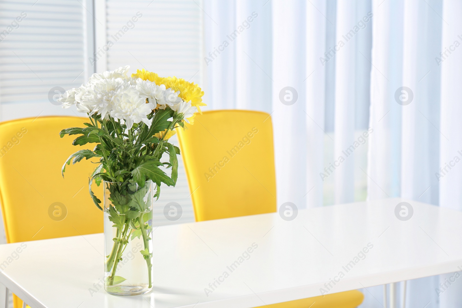 Photo of Vase with blooming flowers on table indoors