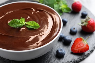 Delicious chocolate cream with berries and mint on table, closeup