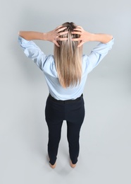 Photo of Young woman on grey background, back view