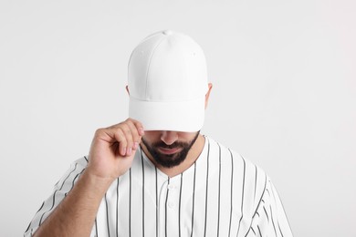 Man in stylish baseball cap on white background