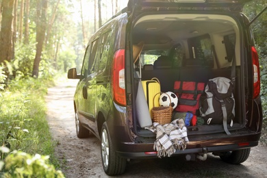 Van with camping equipment in trunk outdoors