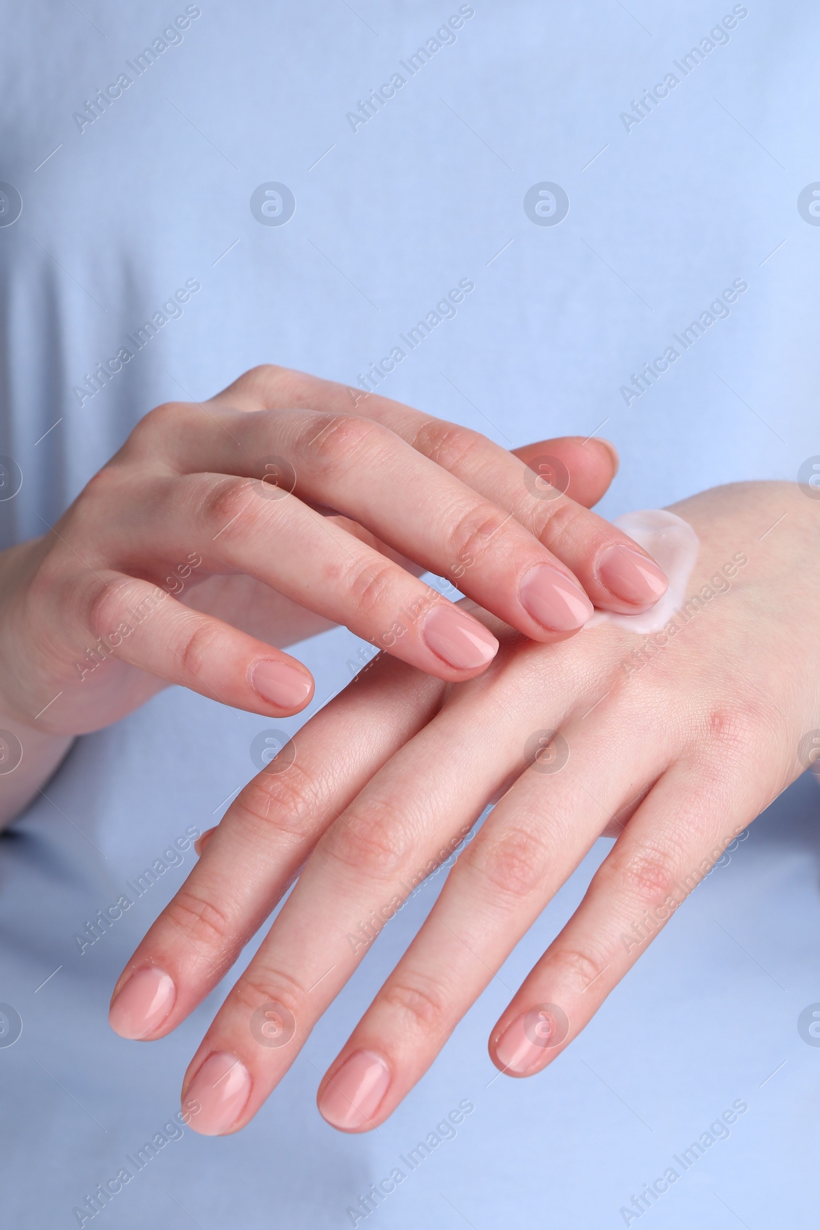 Photo of Woman applying cream on her hands, closeup