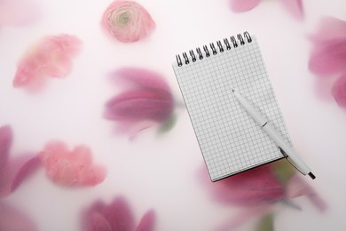 Photo of Guest list. Notebook and pen on spring floral background, flat lay. Space for text