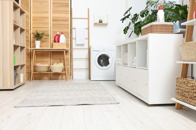 Photo of Laundry room interior with washing machine and furniture