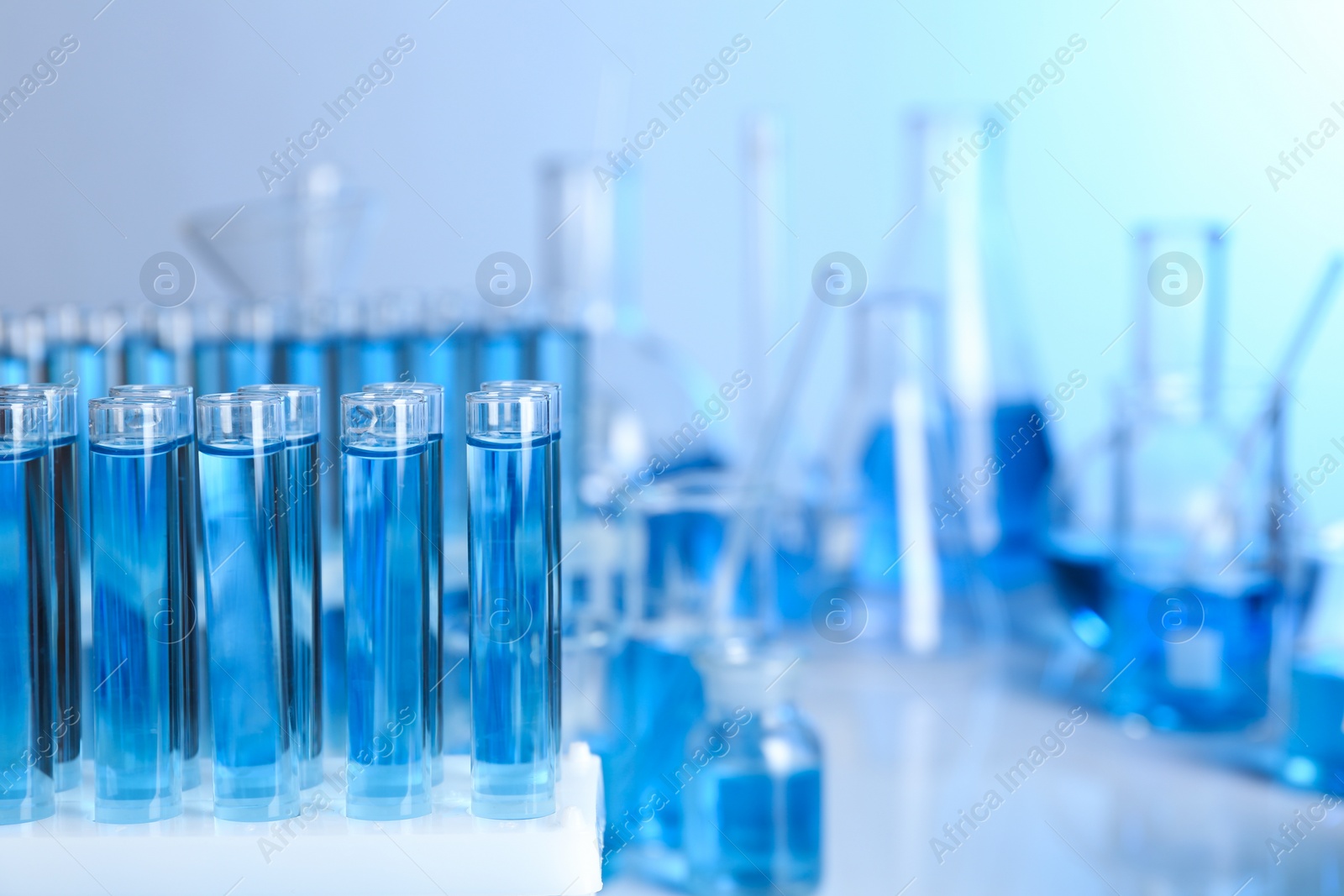 Photo of Test tubes with liquid samples for analysis in laboratory, closeup. Space for text