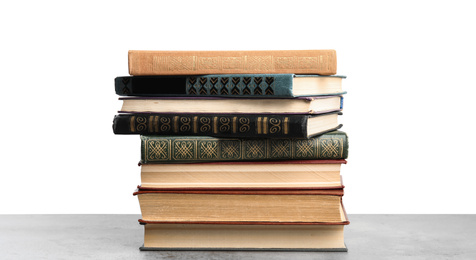 Photo of Stack of old vintage books on stone table against white background
