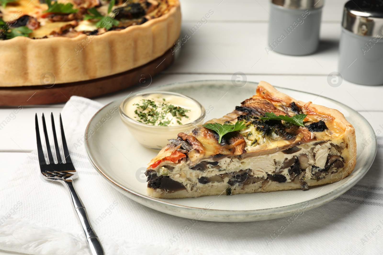 Photo of Piece of delicious quiche with mushrooms and parsley served on white table, closeup