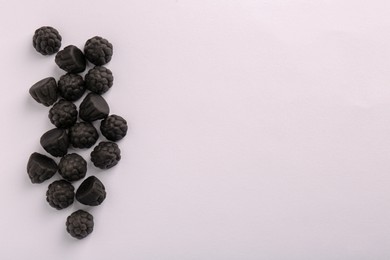 Tasty liquorice candies on light background, top view. Space for text