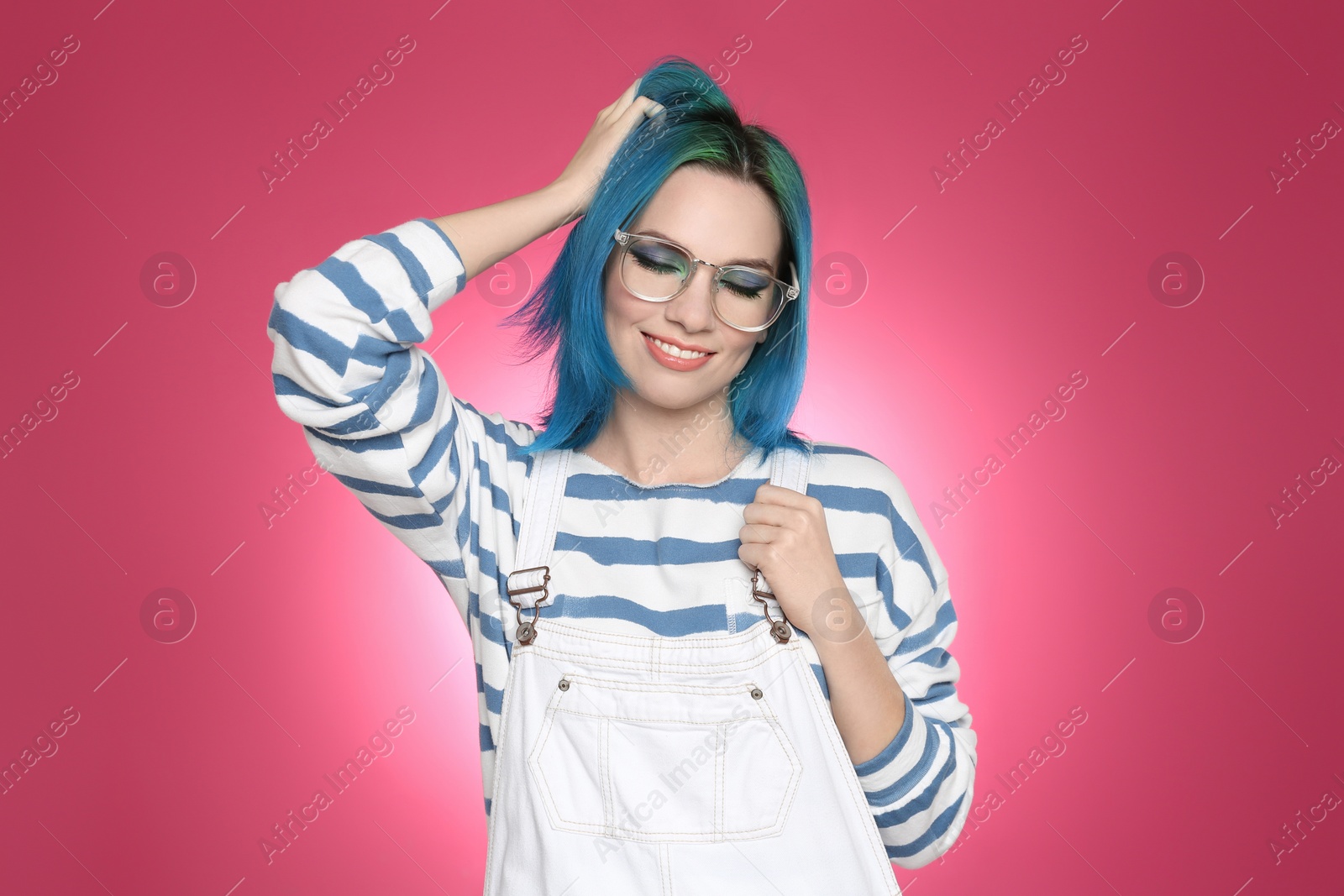 Photo of Young woman with bright dyed hair on pink background