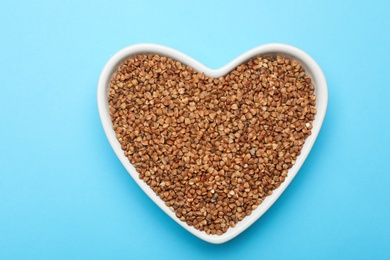 Photo of Buckwheat grains on light blue background, top view