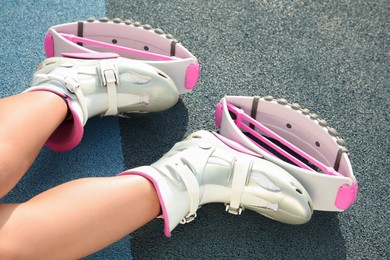 Woman with kangoo jumping boots on color textured background, closeup