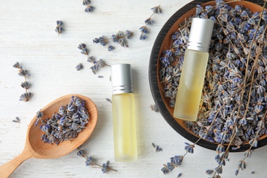 Photo of Flat lay composition with essential oil and flowers on wooden table