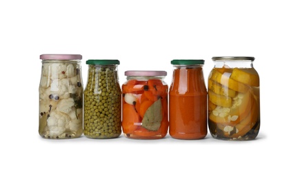 Different jars with pickled vegetables on white background