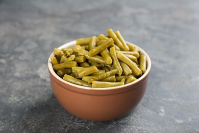 Photo of Canned green beans in bowl on grey table