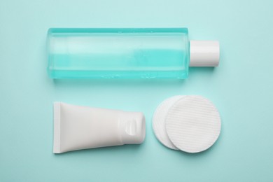 Photo of Flat lay composition with bottle of micellar cleansing water on turquoise background