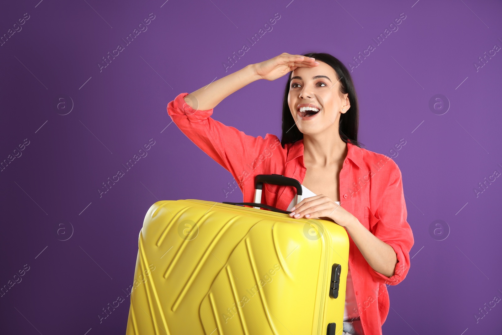 Photo of Beautiful woman with suitcase for summer trip on purple background. Vacation travel