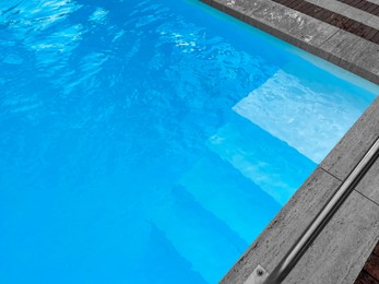 Outdoor swimming pool in luxury hotel on sunny summer day, above view. Time for relax