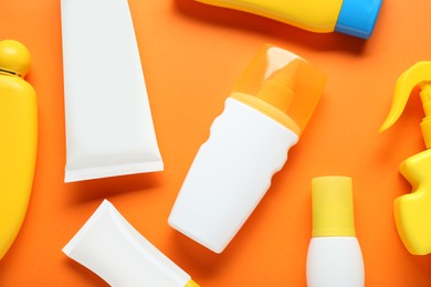 Photo of Suntan products on orange background, flat lay