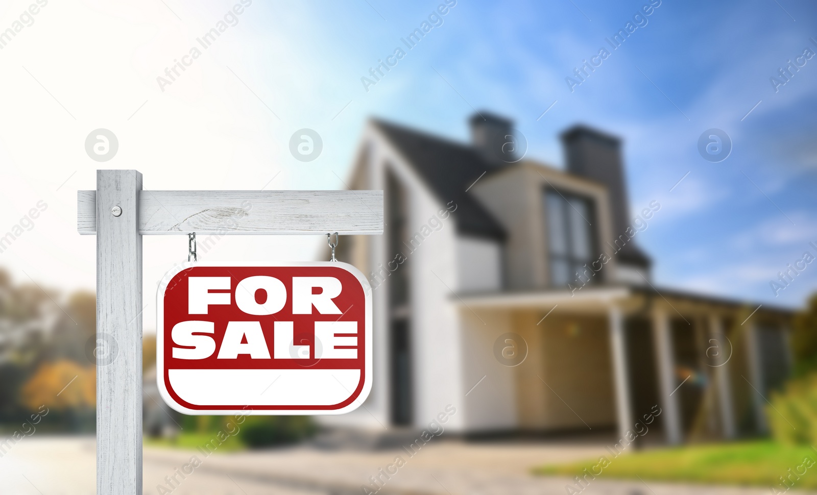 Image of Red real estate sign with inscription FOR SALE near house outdoors on sunny day, space for text 