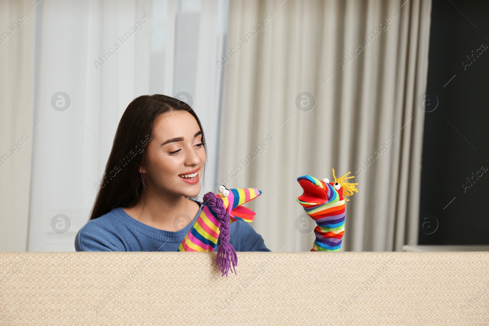 Photo of Young woman performing puppet show at home