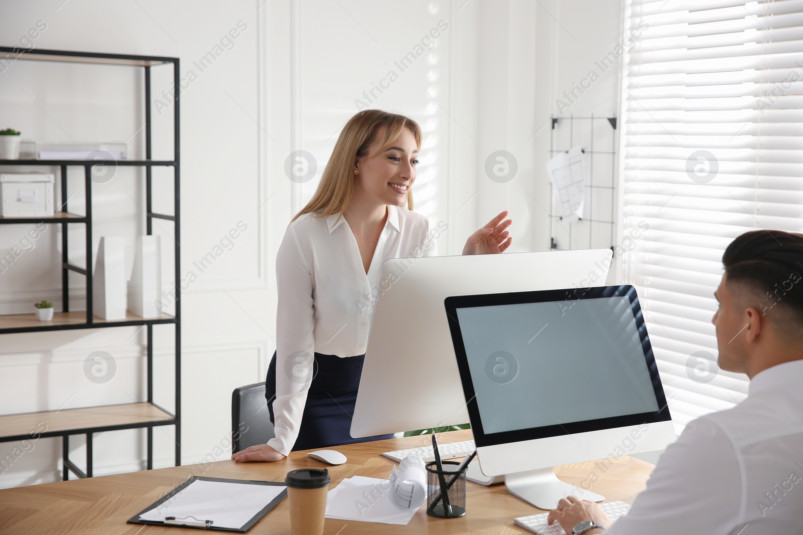 Photo of Young woman flirting with her colleague during work in office