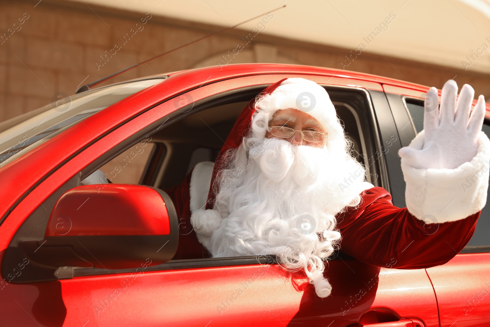 Photo of Authentic Santa Claus driving his modern car, outdoors