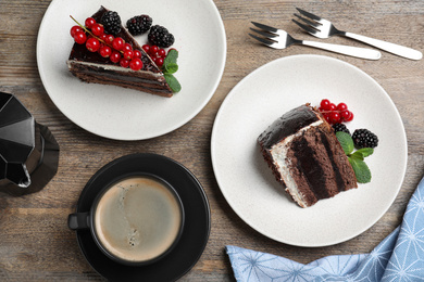 Tasty chocolate cake with berries on wooden table, flat lay