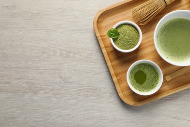 Photo of Fresh matcha tea, bamboo whisk and green powder on wooden table, top view. Space for text